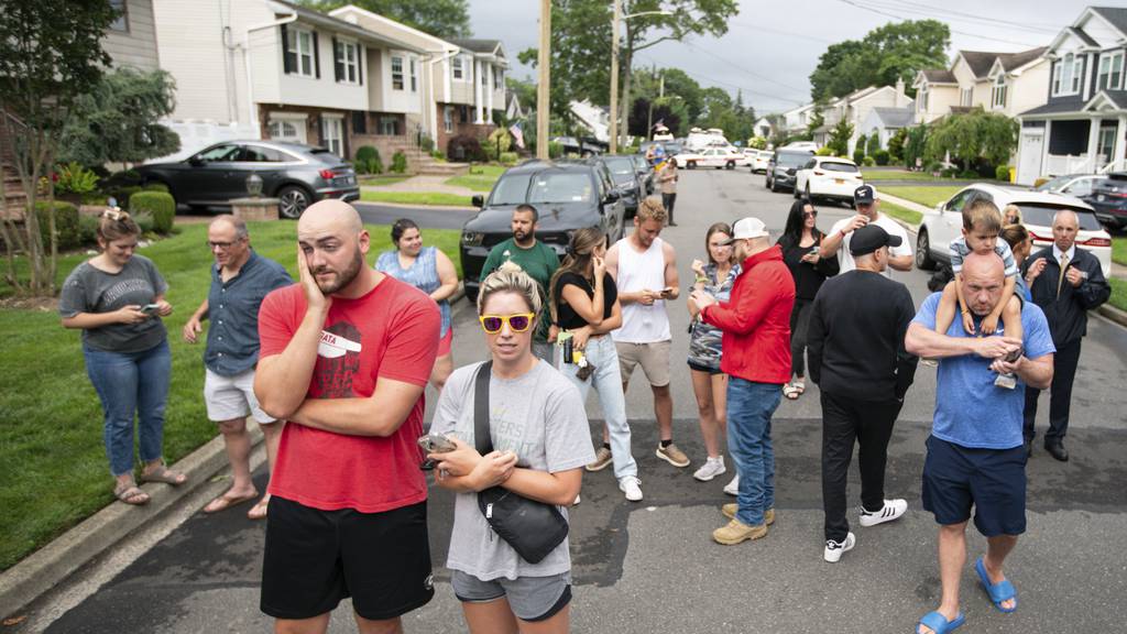 Residents try to take a look as police officers search the house Massapequa Park that was home to Rex Heuermann, a suspect charged in three of the Gilgo Beach murders.