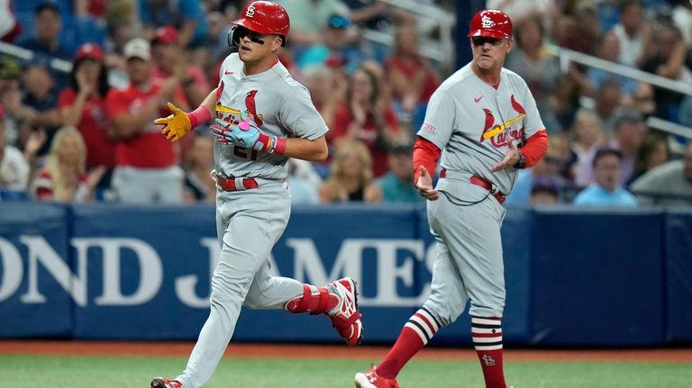 St. Louis Cardinals' Lars Nootbaar, left, celebrates with third base...