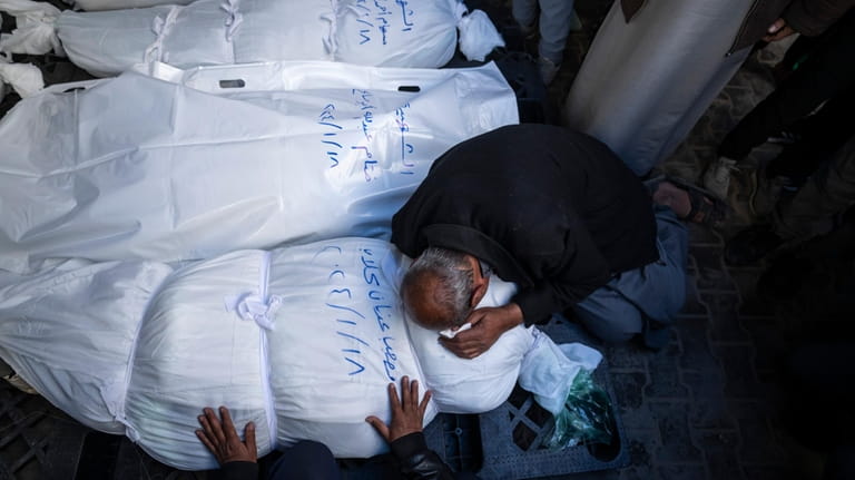 Palestinians mourn their relatives killed in the Israeli bombardment of...