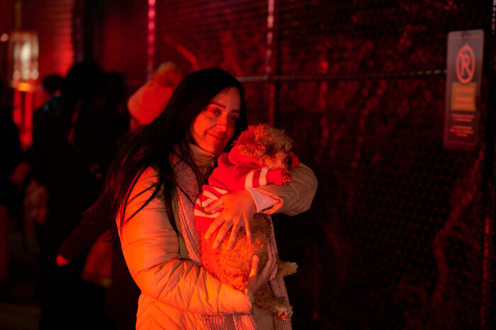 A building resident carries her soot-covered dog away from a three alarm fire at 920 Summit Ave. on Tuesday, Jan. 2, 2024.