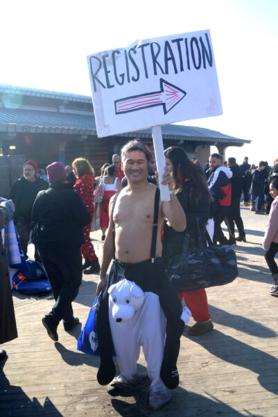 Eddie Mark, community Board 13 district manager and Coney Island Polar Bear Club member, holding a registration sign.