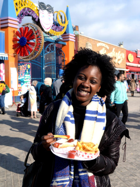 A participant celebrates with some Coney Island food on the boardwalk.