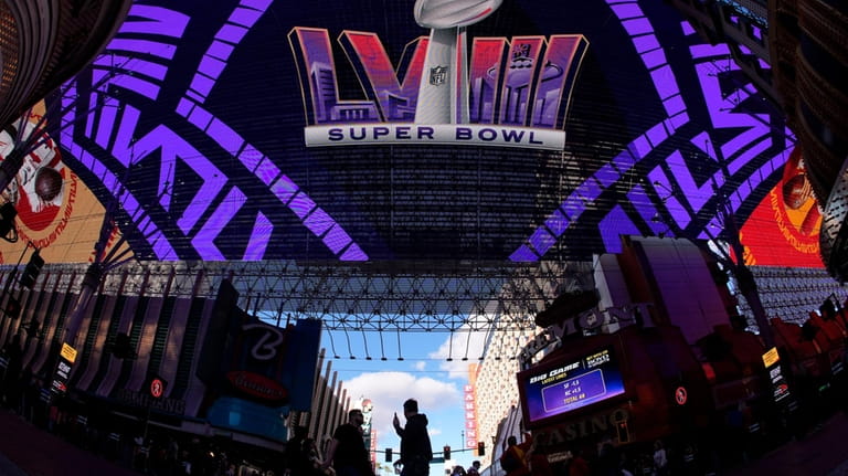 People cross a street at the Fremont Street Experience ahead...