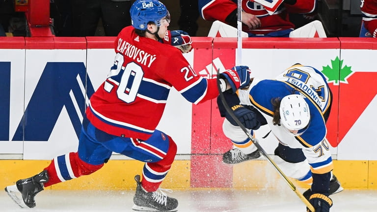 Montreal Canadiens' Juraj Slafkovsky (20) checks St. Louis Blues' Oskar...