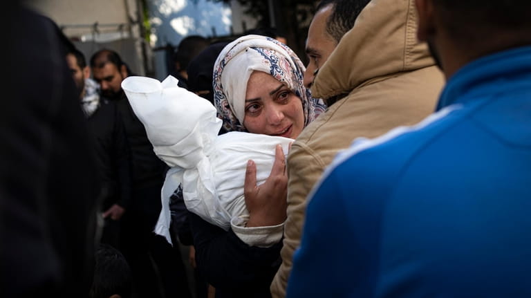 Palestinians mourn relatives killed in the Israeli bombardment of the...