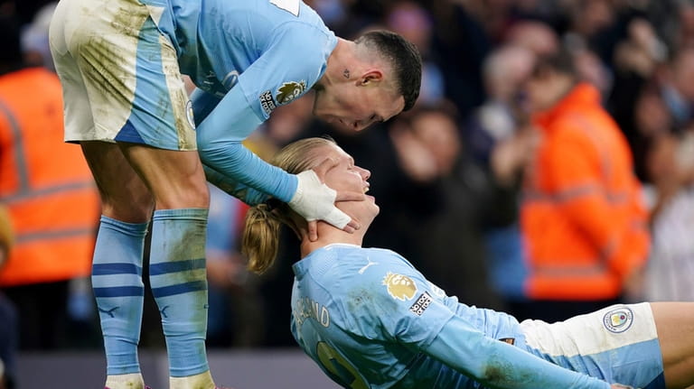 Manchester City's Erling Haaland, right, celebrates with teammate Phil Foden,...