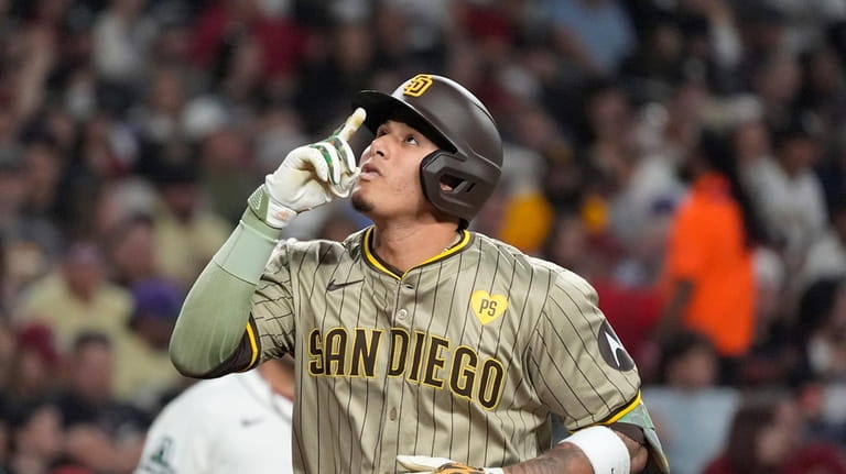 San Diego Padres' Manny Machado points to the sky as...